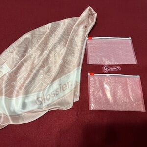 Glossier bundle, scarf, two pink bags, and fall 2025 sticker